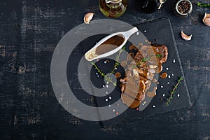 Grilled beef steak with herbs and spices on stone plate