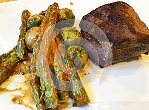 Grilled Beef Steak. Juicy beef steak. Gourmet steak with vegetables, grilled asparagus and brussels sprouts with sauce.