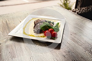 Grilled beef steak and mushrooms with tomatoes on wood table