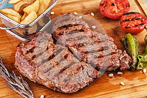 Grilled beef steak with grilled pepper, onion rings and tomatoes.