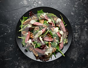 Grilled Beef Steak salad with pears, walnuts and greens vegetables and blue cheese sauce. healthy food.