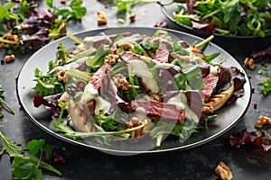 Grilled Beef Steak salad with pears, walnuts and greens vegetables and blue cheese sauce. healthy food.