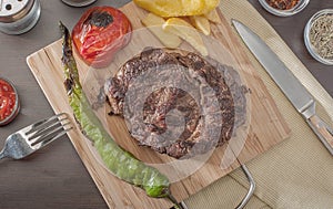 Grilled beef steak served with grilled tomatoes, peppers and chi