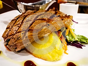 Grilled beef steak served with mashed potatoes and vegetables.