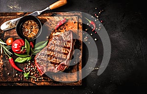 Grilled beef steak with spices and herbs on a cutting board