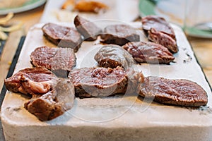 Grilled beef steak on the stone in the foreground. food background