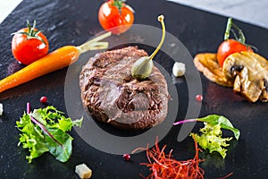 Grilled Beef steak with vegetable decoration. Grilled porterhouse steak on slate board.