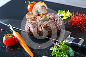 Grilled Beef steak with vegetable decoration. Grilled porterhouse steak on slate board.