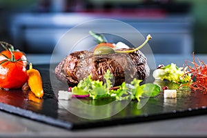 Grilled Beef steak with vegetable decoration. Grilled porterhouse steak on slate board.