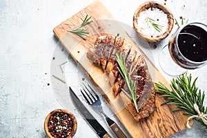 Grilled beef striploin steak with red wine glass.