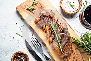 Grilled beef striploin steak with red wine glass.