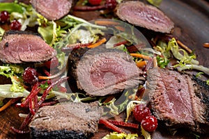 Grilled beef Striploin steak sliced on the grill and a close-up tomato.