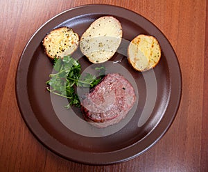 Grilled beef on white plate with potatoes