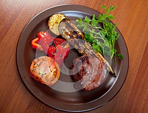 Grilled beef on white plate with vegetable.