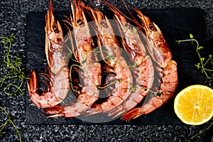 Grilled big tiger shrimps prawns on black slate plate