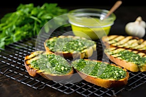 grilled bread on a cooling rack, dollop of garlic herb butter on side