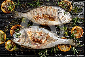 Grilled bream fish, dorada fish with the addition of spices, herbs and lemon on the grill barbecue