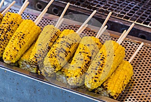 Grilled butter corn with stick on grill table