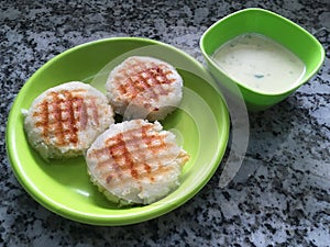 Grilled Butter Idli on a Green Plate and Coconut Dipp