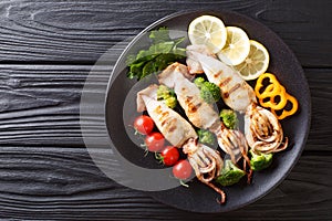 Grilled calamari with tentacles with tomatoes, broccoli, lemon a photo