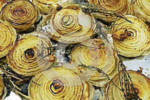 Grilled caramalized white onions with herbs on a metal tray photo