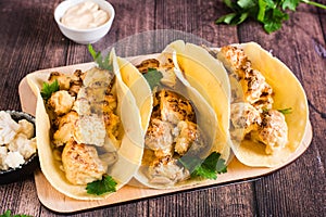 Grilled cauliflower tacos with herbs on a board on the table. Vegetarian food