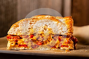 Grilled cheese sandwich with vegan cheese and red bell pepper in front of a rustic wooden background with copy space