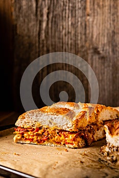 Grilled cheese sandwich with vegan cheese and red bell pepper in front of a rustic wooden background with copy space.