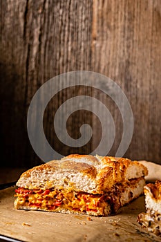 Grilled cheese sandwich with vegan cheese and red bell pepper in front of a rustic wooden background with copy space