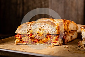 Grilled cheese sandwich with vegan cheese and red bell pepper in front of a rustic wooden background with copy space