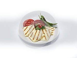 Grilled cheese slices with grilled vegetables on white plate