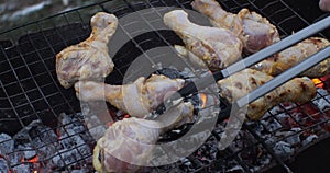 Grilled chicken in the backyard. Coals smolder in the brazier and create heat for cooking meat on coals. The concept of