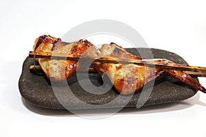 grilled chicken with bamboo sticks on white background