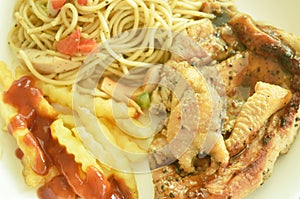 Grilled chicken black pepper steak dressing spicy sauce with French fries and fried spaghetti sausage on plate