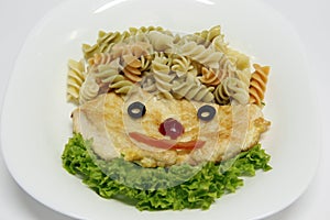 Grilled chicken breast beautifully decorated with pasta and salad like a smiley