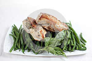 Grilled chicken breast on a bed of green beans