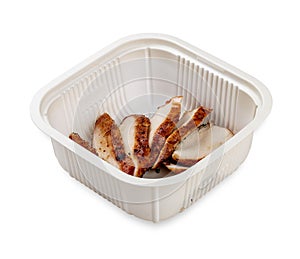 Grilled chicken breast cut into slices. In a plastic container. Food to go. On a light background