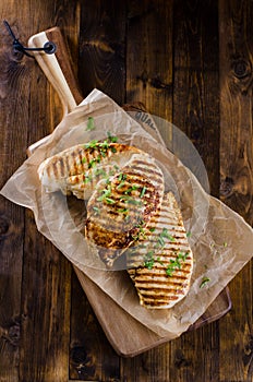 Grilled chicken breast on dark wooden background