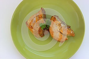 Grilled chicken breast, decorated with a sprig of parsley. View from above