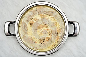 Grilled chicken breast fillets with cooking cream and herb spices in the frying pan