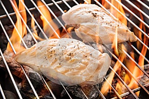 Grilled chicken breast on the flaming grill
