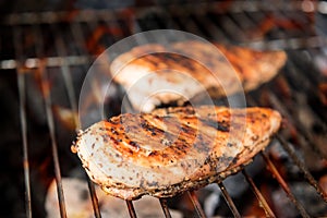 Grilled chicken breast on the flaming grill