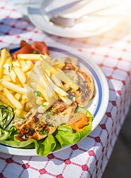 Grilled chicken breast meal with fries