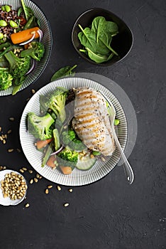 Grilled chicken breast, red rice and fresh broccoli vegetables, carrots, soybeans, spinach for garnish. With pine nuts