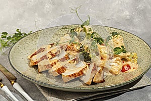 Grilled chicken breast sliced with stewed cauliflower and white sauce