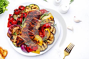 Grilled chicken breast and various vegetables. Colorful paprika, zucchini, eggplant, mushrooms, tomatoes, onion with rosemary on