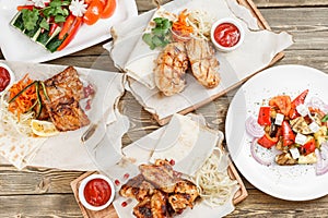 Grilled chicken breast and wings. Serving on a wooden Board on a rustic table. Barbecue restaurant menu, a series of