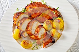 Grilled chicken breasts with browned new potatoes