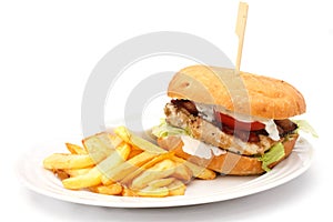 Grilled chicken burger with chips on white plate.