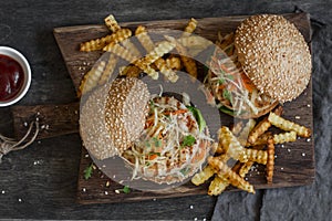 Grilled chicken and coleslaw hamburgers on a wooden board